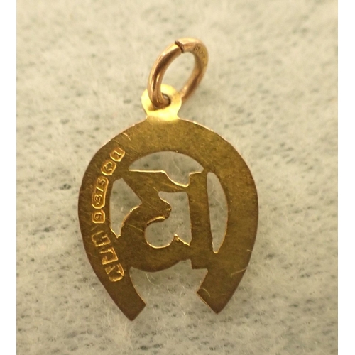 397 - A 9CT GOLD HORSE SHOE PENDANT numbered 