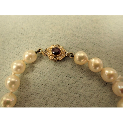 411 - A STRING OF BAROQUE PEARLS WITH RUBY, DIAMOND AND PEARL GOLD CLASP