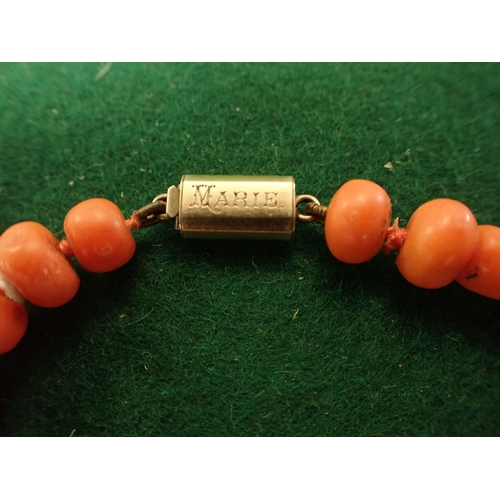 412 - A ROW OF GRADUATED CORAL BEADS with gold claps engrave 'Marie'