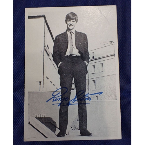 553 - A SIGNED BLACK AND WHITE PHOTOGRAPH OF JOHN LENNON holding a young boy, signed 'John Lennon' in red ... 