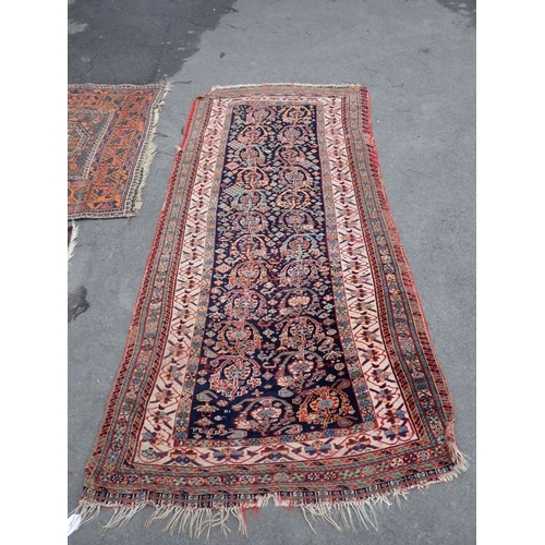 665 - AN ANTIQUE TALISH RUNNER woven in colours with endless Boteh repeat, on a dark blue ground, within m... 