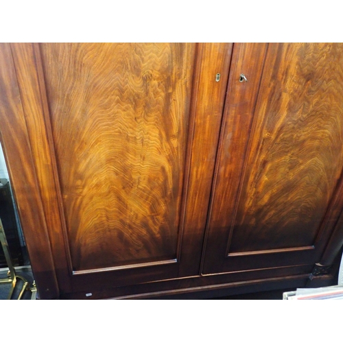 699 - A WILLIAM IV MAHOGANY WARDROBE with plain projecting cornice over a pair of Gothic panelled doors wi... 