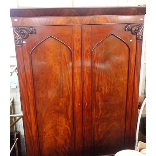 699 - A WILLIAM IV MAHOGANY WARDROBE with plain projecting cornice over a pair of Gothic panelled doors wi... 