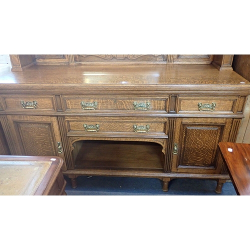 706 - A LATE VICTORIAN OAK BUFFET the mirrored superstructure with swan-neck pediment, over an arrangement... 