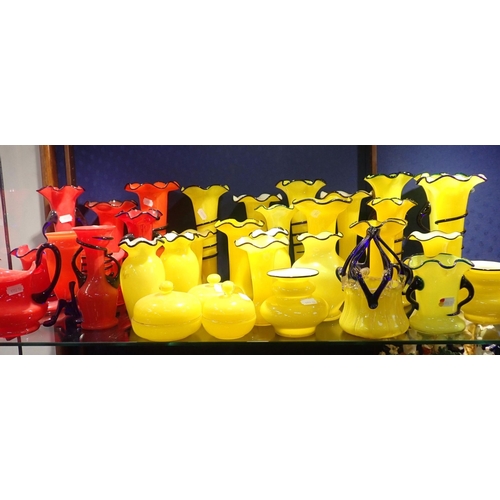 77 - A COLLECTION OF YELLOW AND RED GLASS VASES much with blue trailed decoration ,and similar