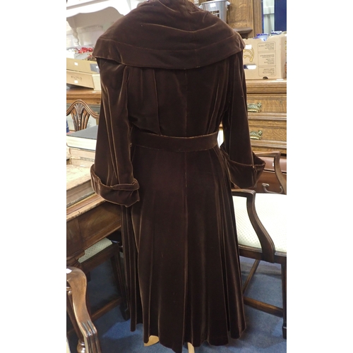 82 - A 1940S BROWN VELVET EVENING COAT with broad collar, buckled belt and quilted lining