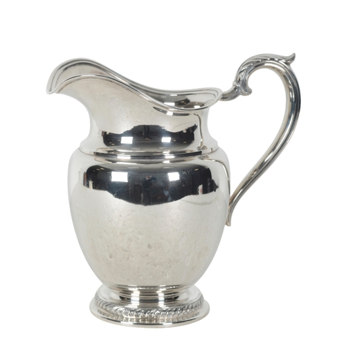 14 - AN AMERICAN STERLING SILVER WATER JUG by Rogers, with leaf capped scroll handle and circular gadroon... 