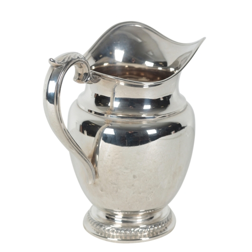 14 - AN AMERICAN STERLING SILVER WATER JUG by Rogers, with leaf capped scroll handle and circular gadroon... 