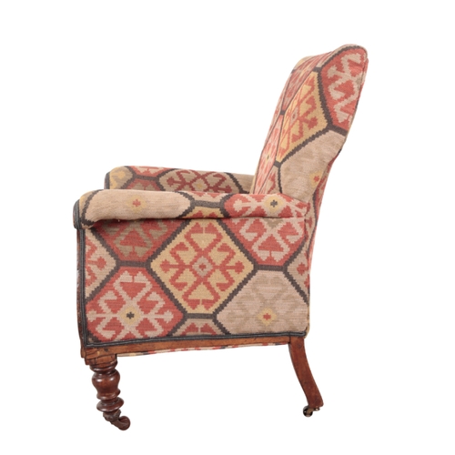 179 - A VICTORIAN KILIM COVERED ARMCHAIR 19th century, the square back over scrolling arms and a shaped se... 