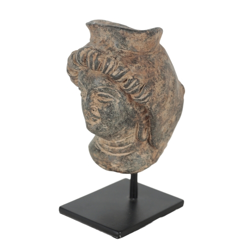 226 - A GANDHARAN STYLE TERRACOTTA HEAD on a modern metal stand, 13cm high; and three other 