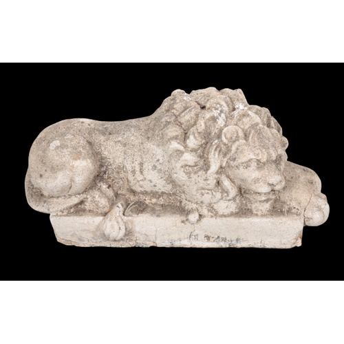 367 - A COMPOSITE STONE MODEL OF A RECUMBENT LION on a plinth base, 28cm high x 55cm long