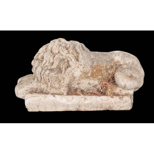 367 - A COMPOSITE STONE MODEL OF A RECUMBENT LION on a plinth base, 28cm high x 55cm long