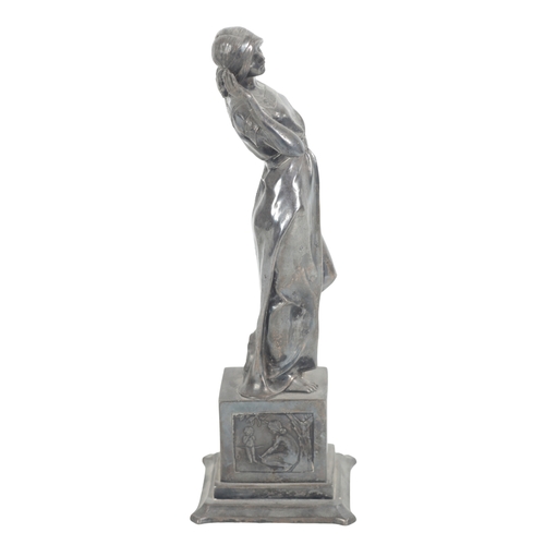 393 - A SILVERED FIGURE OF A WOMAN 20th century, cast on a plinth with relief carved panels to the side, 3... 