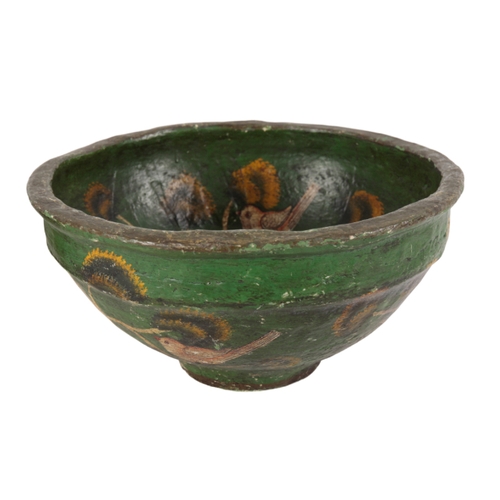 408 - A PAINTED PAPIER MACHE CIRCULAR BOWL naively decorated with birds and trees on a green ground, 39cm ... 