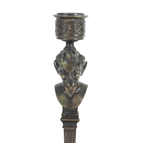 422 - A PAIR OF BRONZE CANDLESTICKS with turned sconces over satyrs head finials, on tapering fluted colum... 