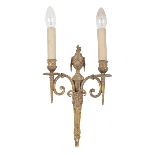 434 - A PAIR OF REGENCY STYLE GILT METAL WALL APPLIQUES with flame and urn finials above twin scrolling br... 