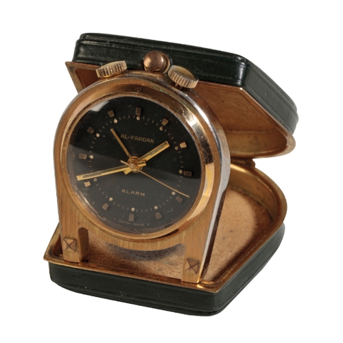 444 - AL-FARDAN: A MINIATURE BRASS PURSE ALARM CLOCK with manual key wind movement, the black dial with go... 