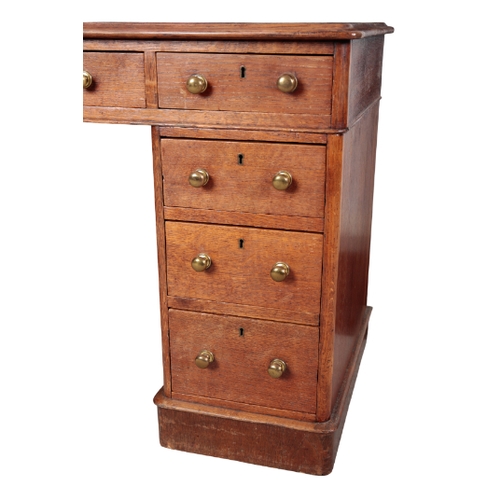 452 - A VICTORIAN OAK KNEEHOLE DESK the top inset with gilt tooled green leather, fitted nine drawers with... 