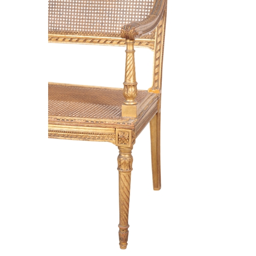 492 - A LOUIS XVI STYLE GILTWOOD SETTEE 20th century, the square caned back having a cresting rail centred... 