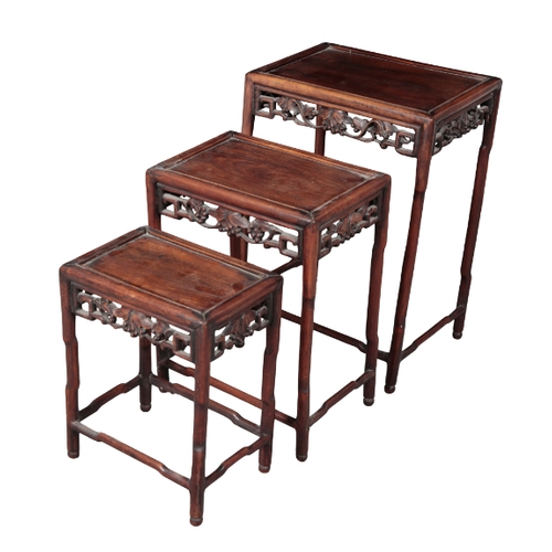 499 - A NEST OF THREE CHINESE HARDWOOD TABLES late 19th/early 20th century, the moulded rectangular tops o... 