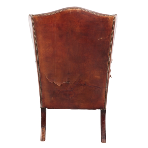 523 - A MAHOGANY WING ARMCHAIR late 19th / early 20th Century, upholstered in studded brown leather, on ca... 