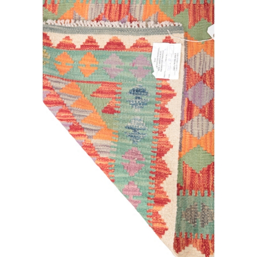 581 - A CONTEMPORARY ANATOLIAN STYLE KILIM RUG woven in colours with two lozenge medallions, on a green gr... 