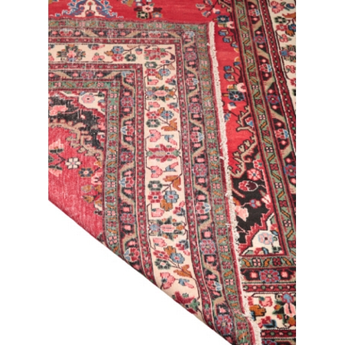 590 - A NORTH WEST PERSIAN MAHAL CARPET with a central medallion on a rich red ground, within conforming b... 