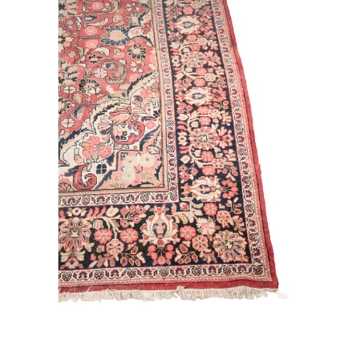 597 - AN ANTIQUE TABRIZ CARPET woven in blue, cream and muted colours with double headed medallion, spandr... 