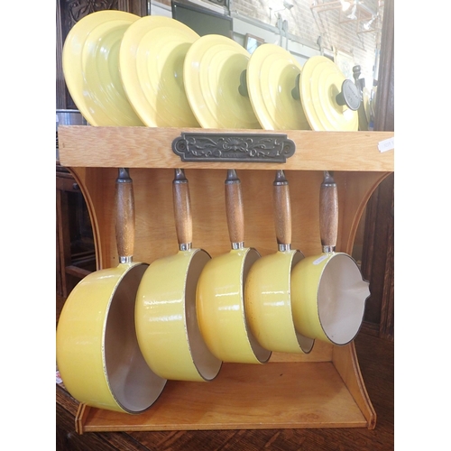 56 - A SET OF LE CREUSET SAUCEPANS, WITH STAND in yellow enamel