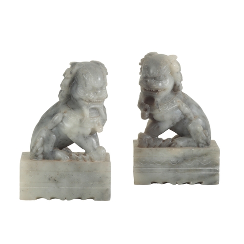 14 - A GROUP OF FIVE CHINESE CARVED SOAPSTONE LION DOGS including a spinach green pair, 20cm high, a smal... 