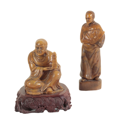 21 - A GROUP OF SIX CHINESE SOAPSTONE FIGURES including a large seal figured as a woman holding a lotus f... 