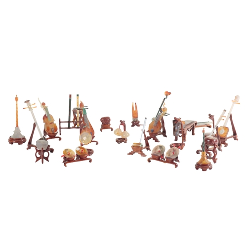 9 - A MINIATURE SET OF CHINESE HARDSTONE INSTRUMENTS a number with wooden stands, the tallest instrument... 