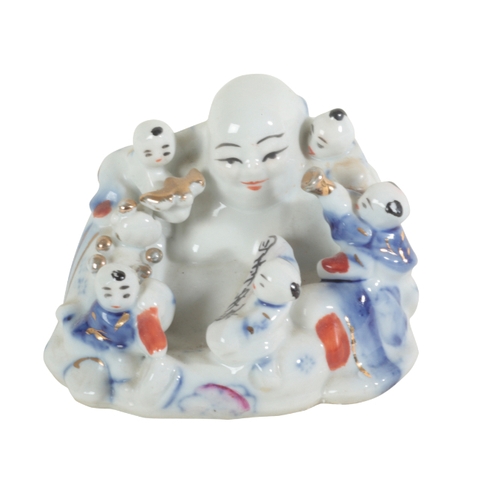 56 - A GROUP OF FIVE CHINESE PORCELAIN FIGURES including a large seated buddha, 20cm high, a pair of fami... 