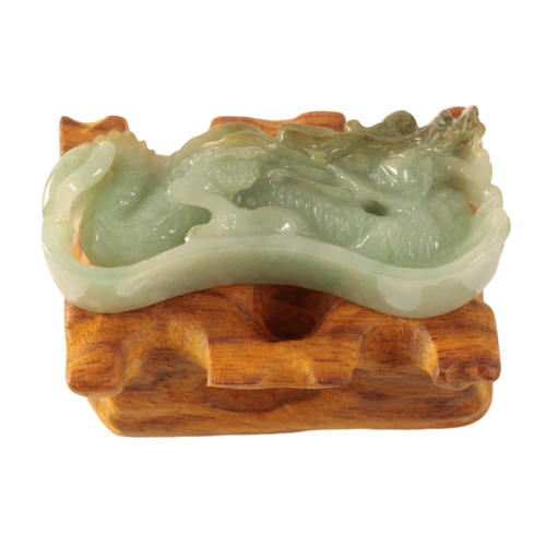 128 - A CHINESE RARE JADE PAPERWEIGHT Qing, 19th century, carved as a dragon with huanghuali wood stand, c... 