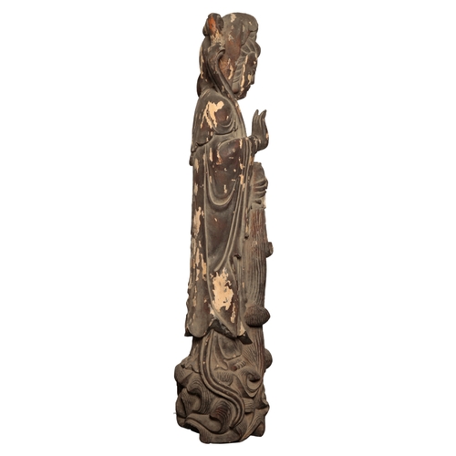 137 - A MONUMENTAL CHINESE LACQUERED WOOD FIGURE OF GUANYIN Qing or later, standing on a wave-scroll base,... 