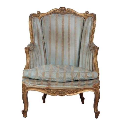 298 - A LOUIS XV STYLE GILTWOOD ARMCHAIR 20th century, with silk covers (worn), the scrolled and carved cr... 