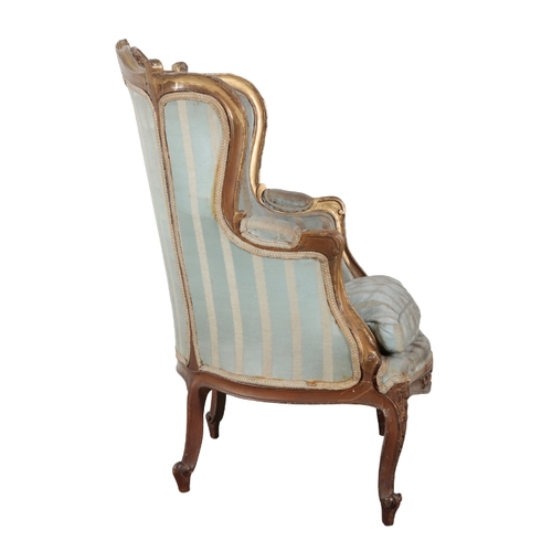 298 - A LOUIS XV STYLE GILTWOOD ARMCHAIR 20th century, with silk covers (worn), the scrolled and carved cr... 