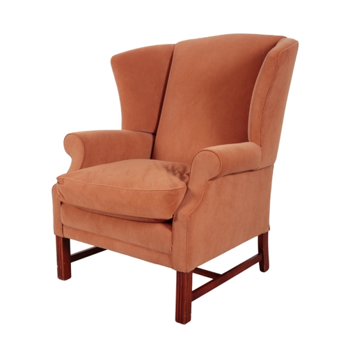 327 - A WINGBACK ARMCHAIR 20th Century, upholstered in pale brown suedette, on moulded mahogany front legs... 