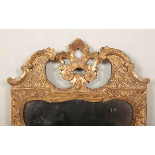 349 - A GEORGE II STYLE GILTWOOD WALL MIRROR with a pierced and c-scrolled cresting, centred by an acanthu... 