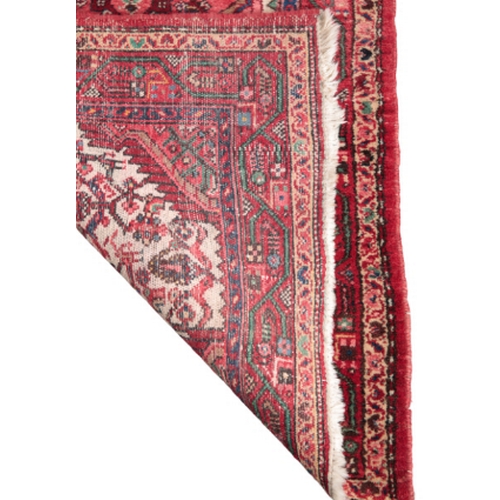 390 - A 20TH CENTURY HAMADAN RUNNER woven in green, blue, pink and other colours with three geometric meda... 