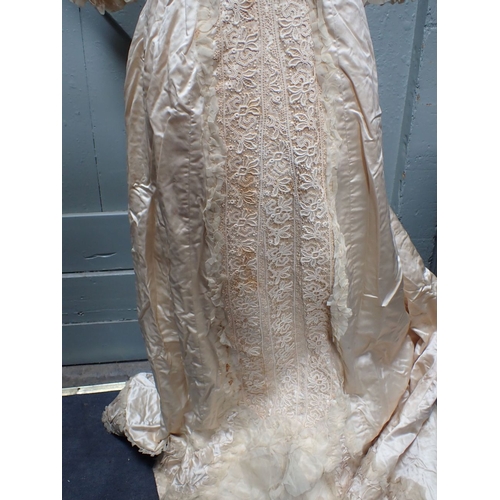 151 - A LATE VICTORIAN SILK WEDDING DRESS, WITH LACE COLLAR AND PANELS in ivory silk, the skirt with train... 