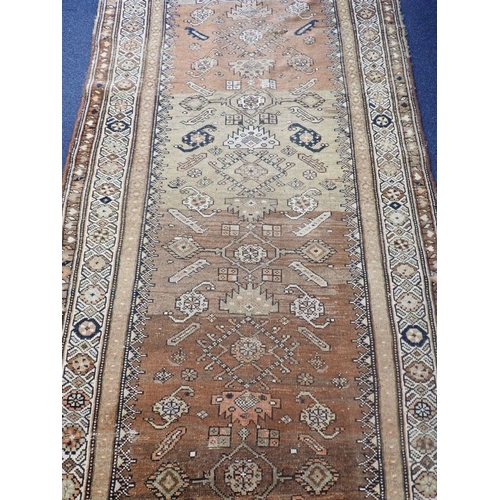 566 - AN ANTIQUE TURKISH RUNNER woven in colours with lozenge and geometric motifs on a yellow and rust co... 