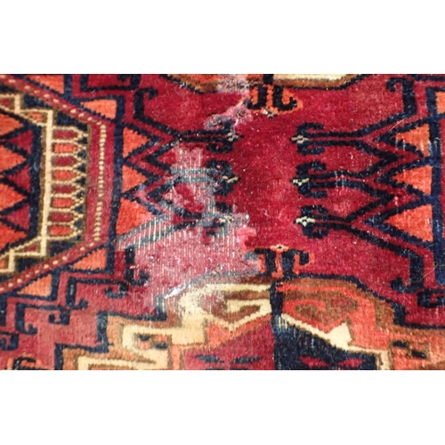 572 - AN ANTIQUE TURKMEN JOVAL woven in muted colours with endless gul repeat on a cochineal red ground wi... 