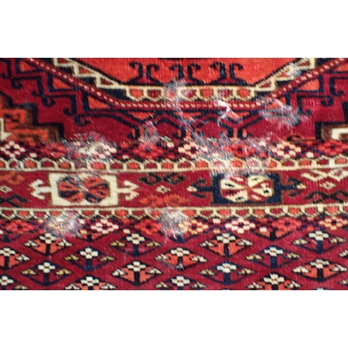 572 - AN ANTIQUE TURKMEN JOVAL woven in muted colours with endless gul repeat on a cochineal red ground wi... 