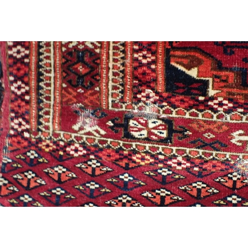 572 - AN ANTIQUE TURKMEN JOVAL woven in muted colours with endless gul repeat on a cochineal red ground wi... 