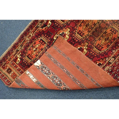 572 - AN ANTIQUE TURKMEN JOVAL woven in muted colours with endless gul repeat on a cochineal red ground wi... 