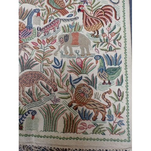 576 - AN INDIAN WOOLWORK PANEL woven in colours with exotic flora and fauna, 144cm x 91cm