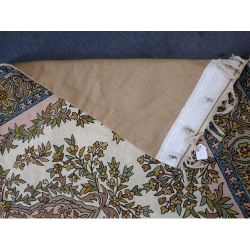 577 - AN INDIAN CREWEL WORK TAPESTRY PANEL woven in muted colours with oval floral and leaf filled medalli... 