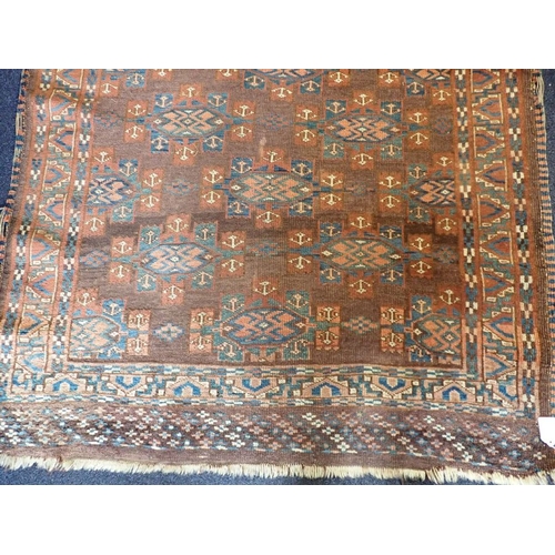 578 - AN ANTIQUE TURKMEN RUG woven in blue, red and white with endless gul repeat on a brown ground, withi... 