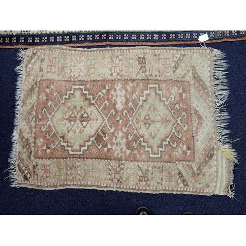 579 - A TURKISH RUG woven in blue and green with twin hooked lozenge medallions on a red ground within geo... 